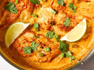 close-up, overhead view of Southwest Creamed Corn and Chicken Skillet, garnished with herbs, green onions, and lime slices
