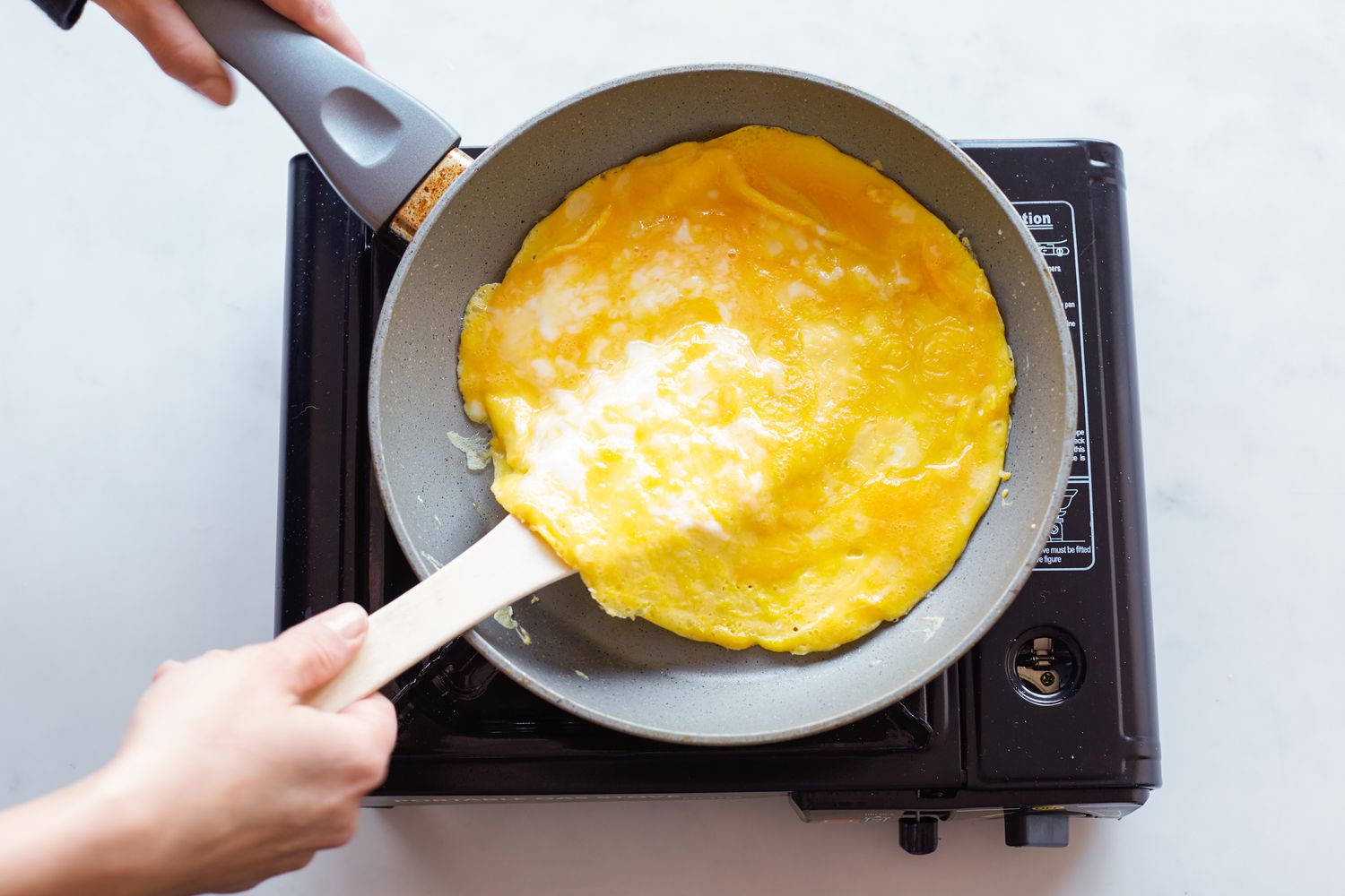 A spatula lifting the omelet for rice cake soup.
