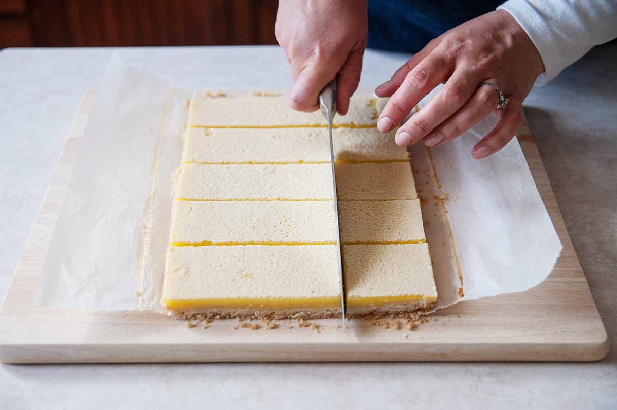 How to Make Lemon Bars - lemon bars being cut on cutting board
