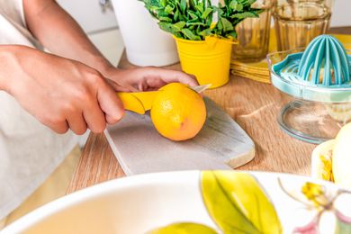 hands cutting a lemon