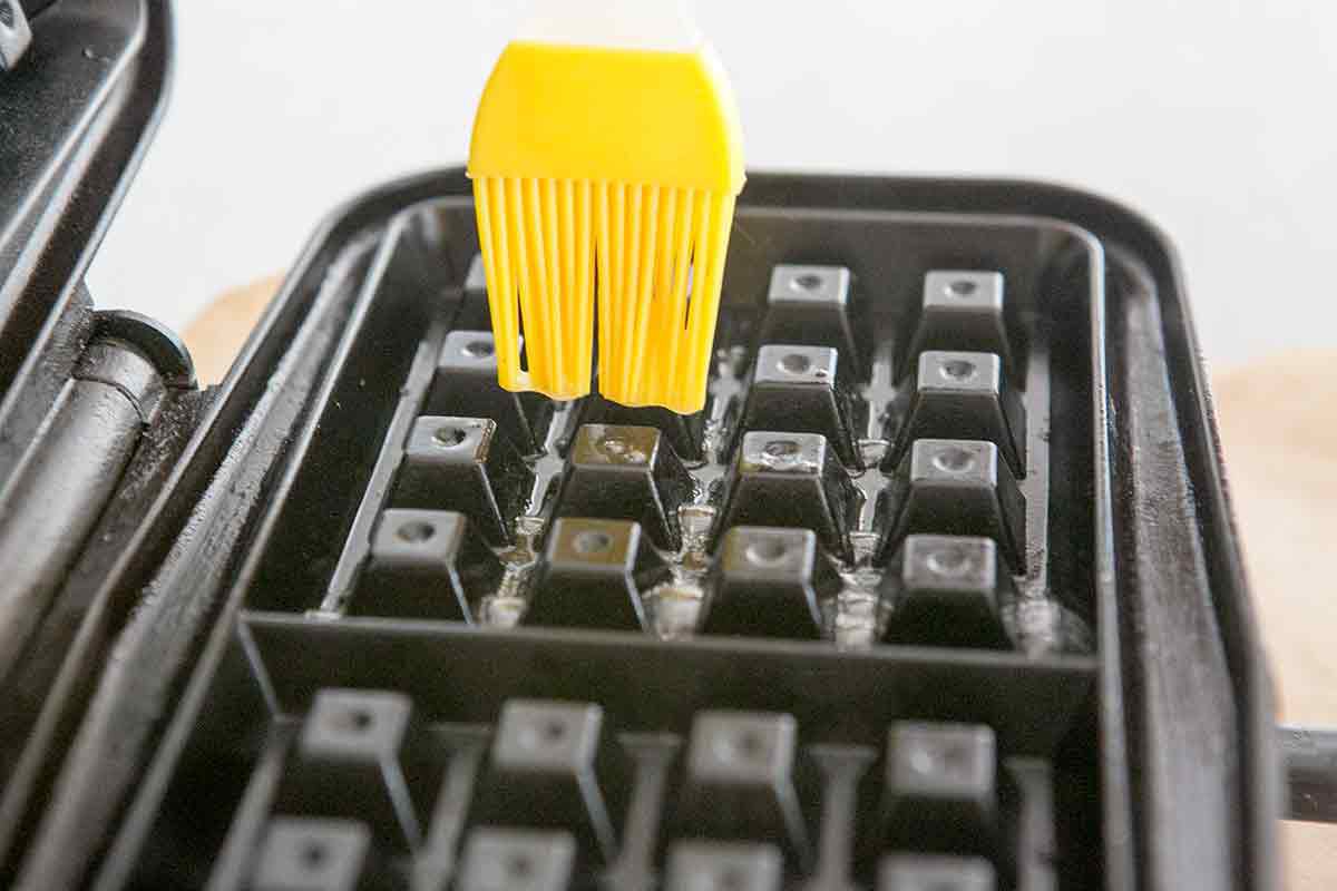 brushing melted butter over waffle iron