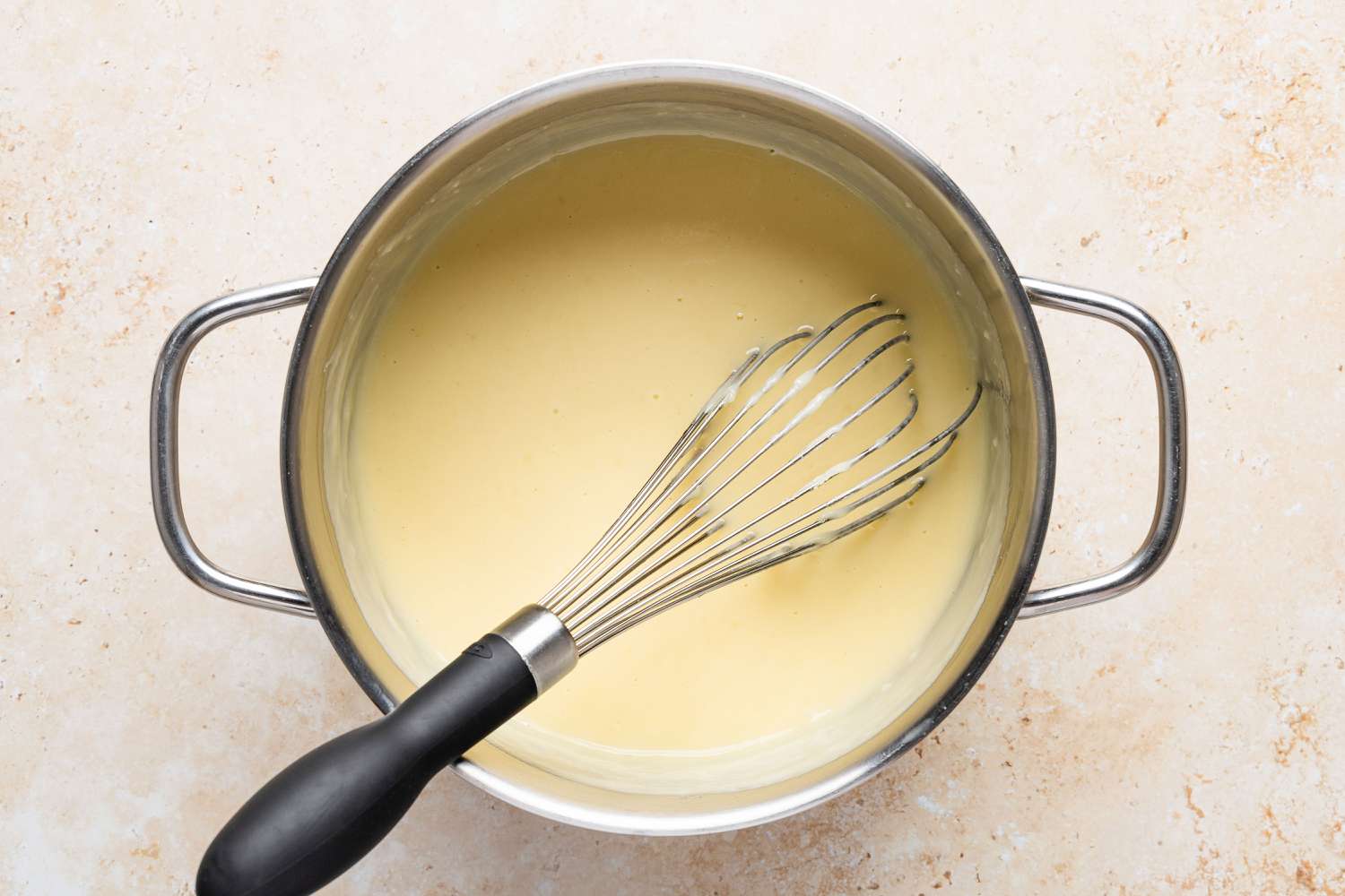 batter mixture in a pot with a whisk for Migliaccio (Italian Ricotta and Semolina Cake)
