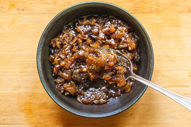 Balsamic onion jam in a grey bowl with a spoon.