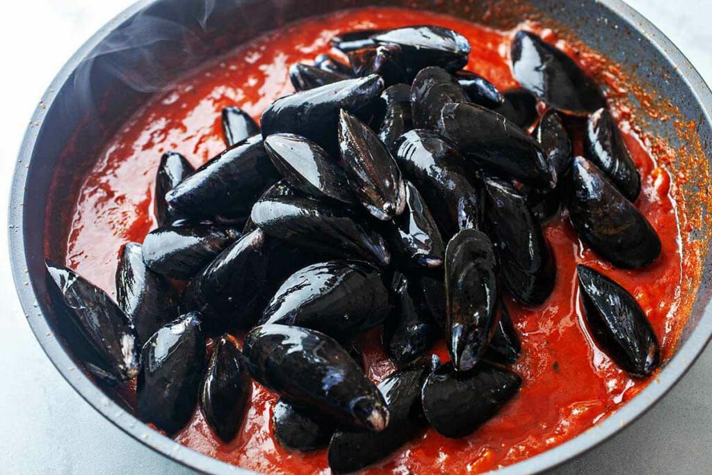 Spaghetti with mussels - mussels in pan of tomato sauce