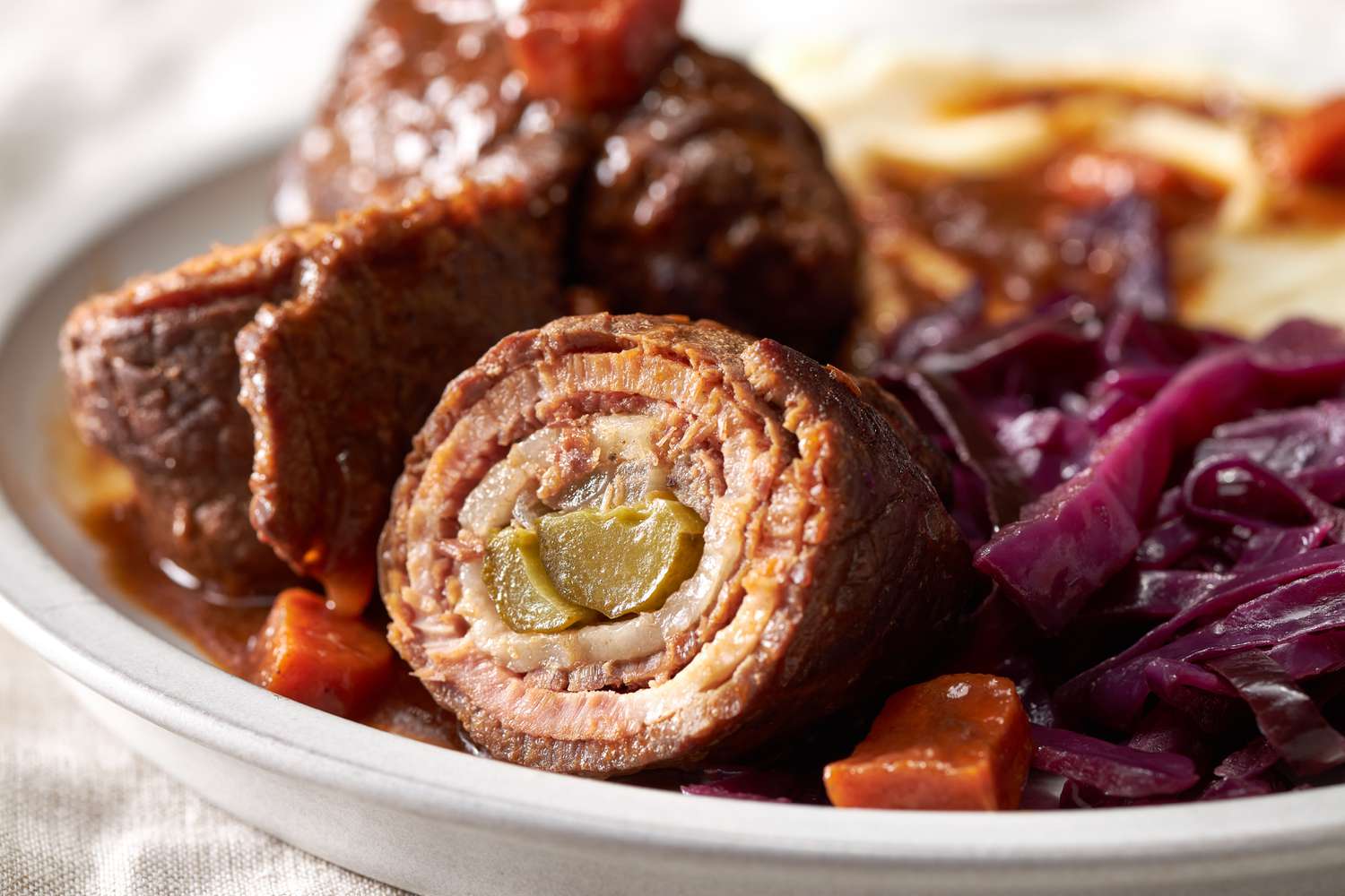 German rouladen on a plate with cabbage and potatoes and gravy