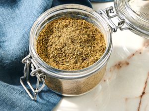 Jar of Poultry Seasoning Next to a Navy Blue Table Napkin