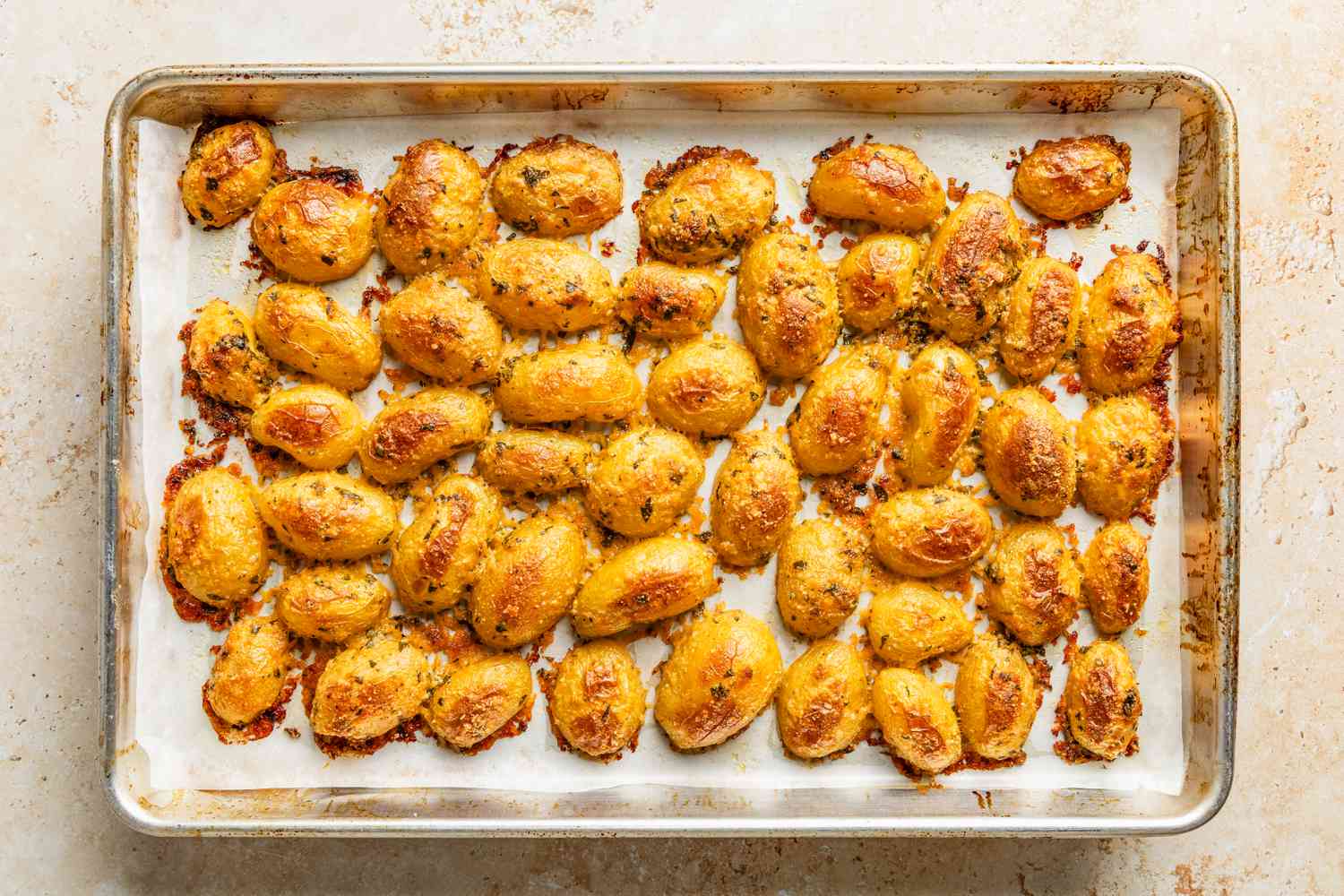 crispy parmesan potatoes on a baking sheet 