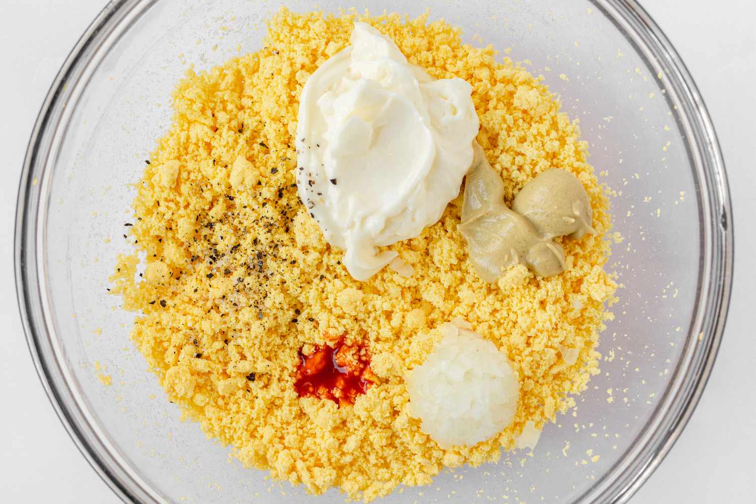 Spices and sour cream added to the egg yolks to make Classic Deviled Eggs.