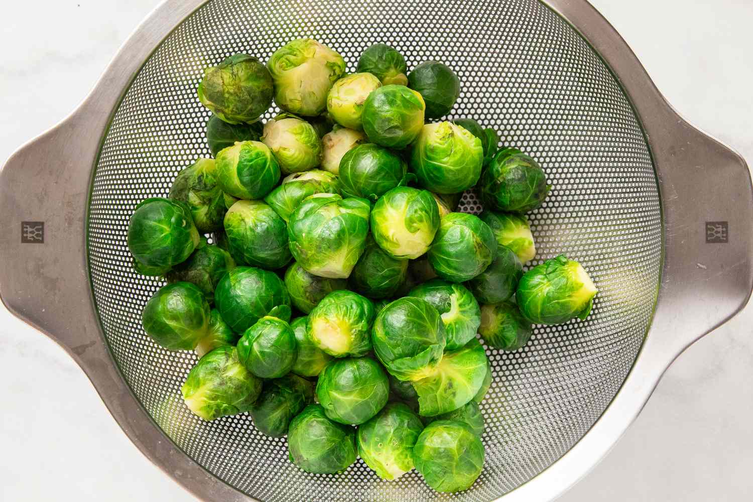 Brussels sprouts in a colander after boiling for Smashed Brussels Sprouts recipe