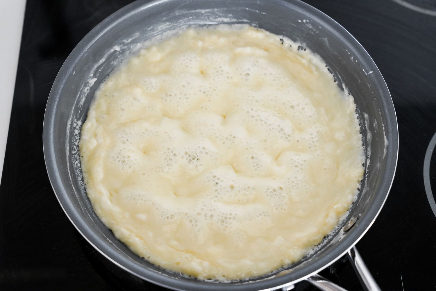 Homemade Condensed Milk Boiling Down in a Pan on the Stove