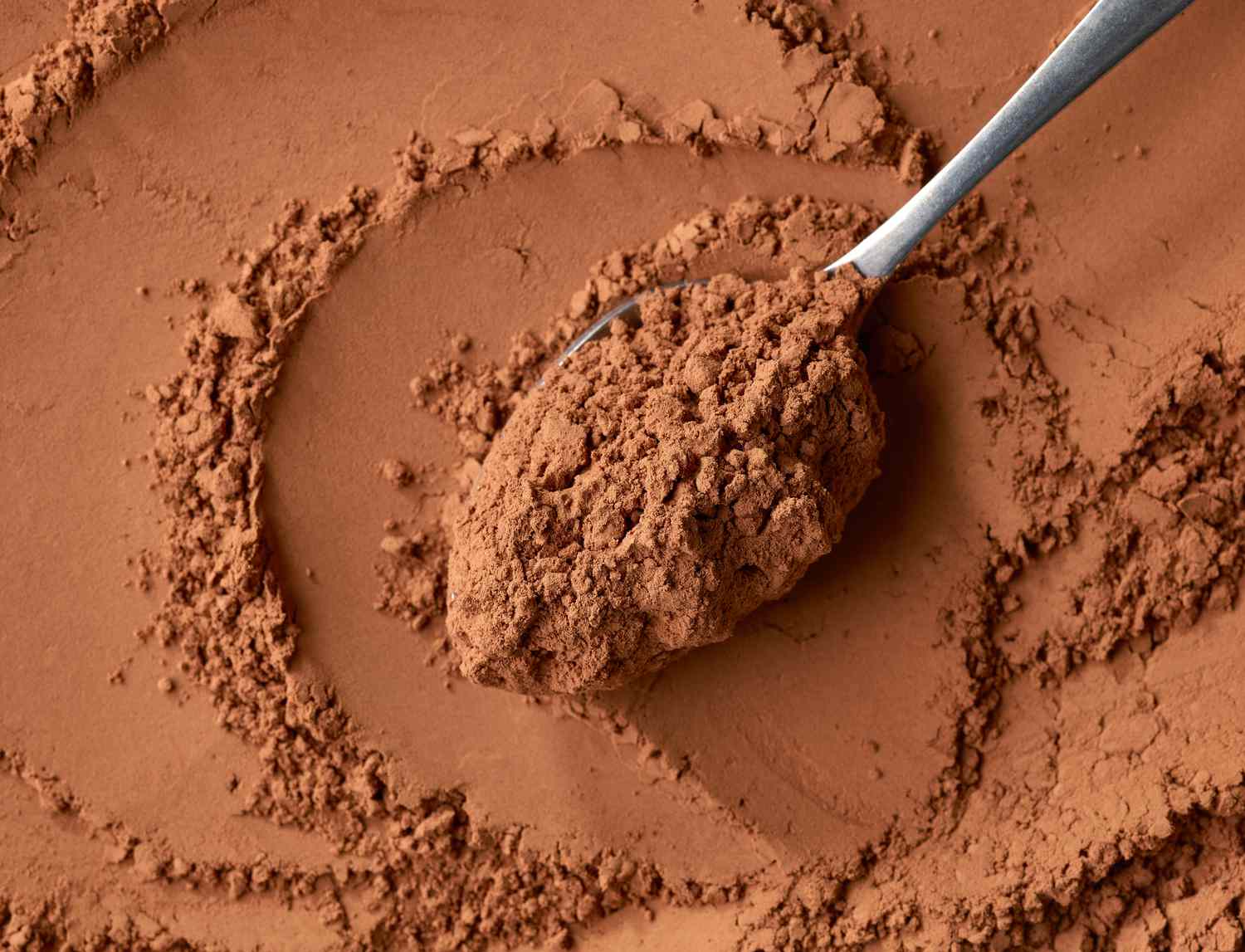 A spoon full of cocoa powder