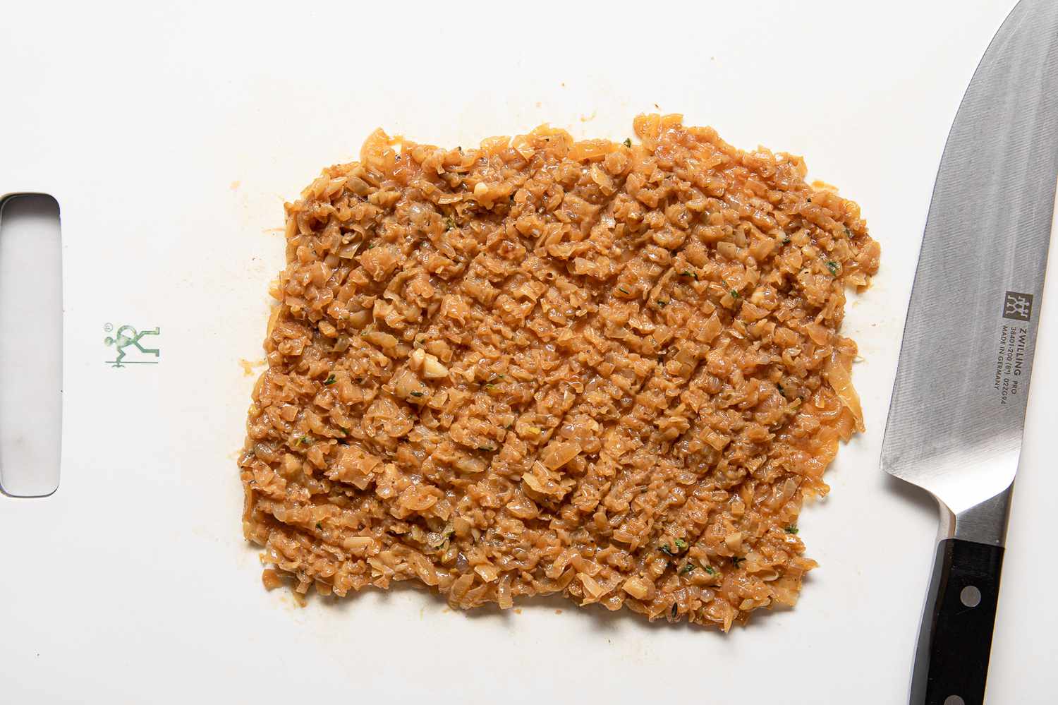 Minced Caramelized Onions on a Cutting Board Next to a Knife for French Onion Meatballs Recipe 