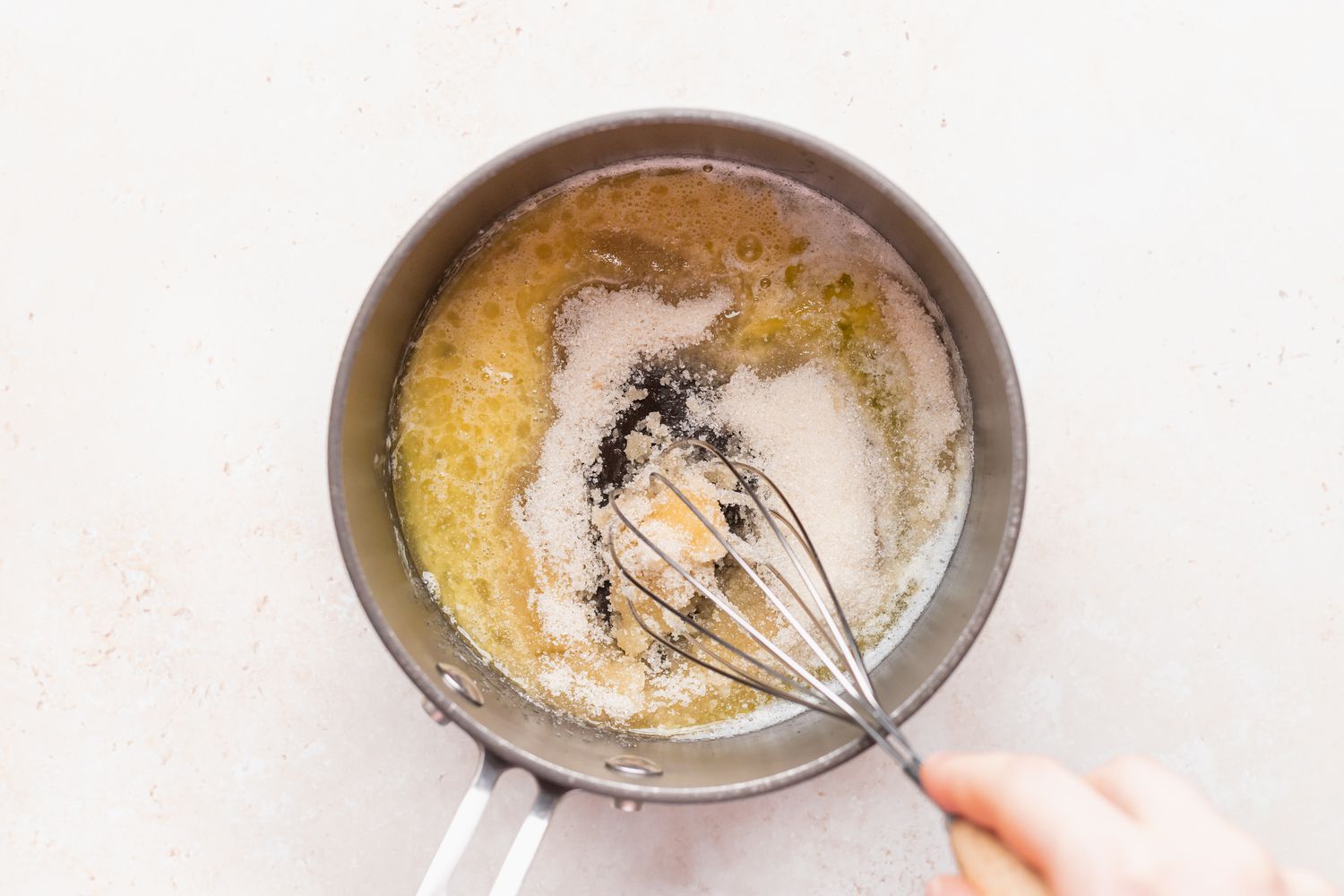 Whisking bread pudding sauce in a saucepan.