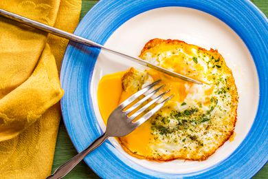 fried runny egg over easy with salt, pepper, and parsley
