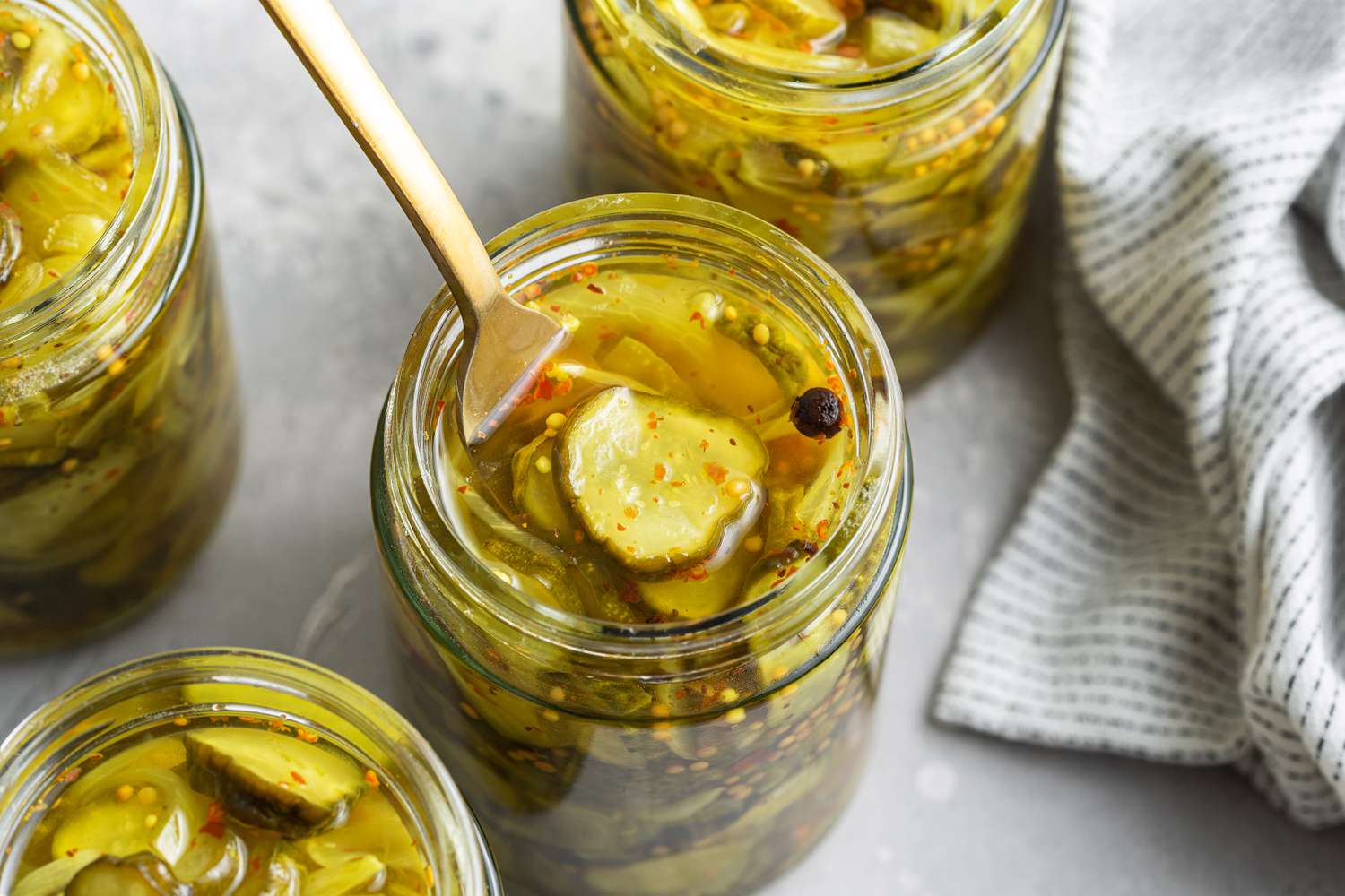 Bread and Butter Pickles being picked up from a Jar Using a Fork