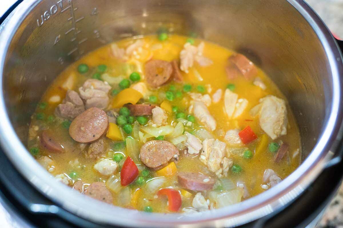 Stir all the ingredients for instant pot paella together before pressure cooking.