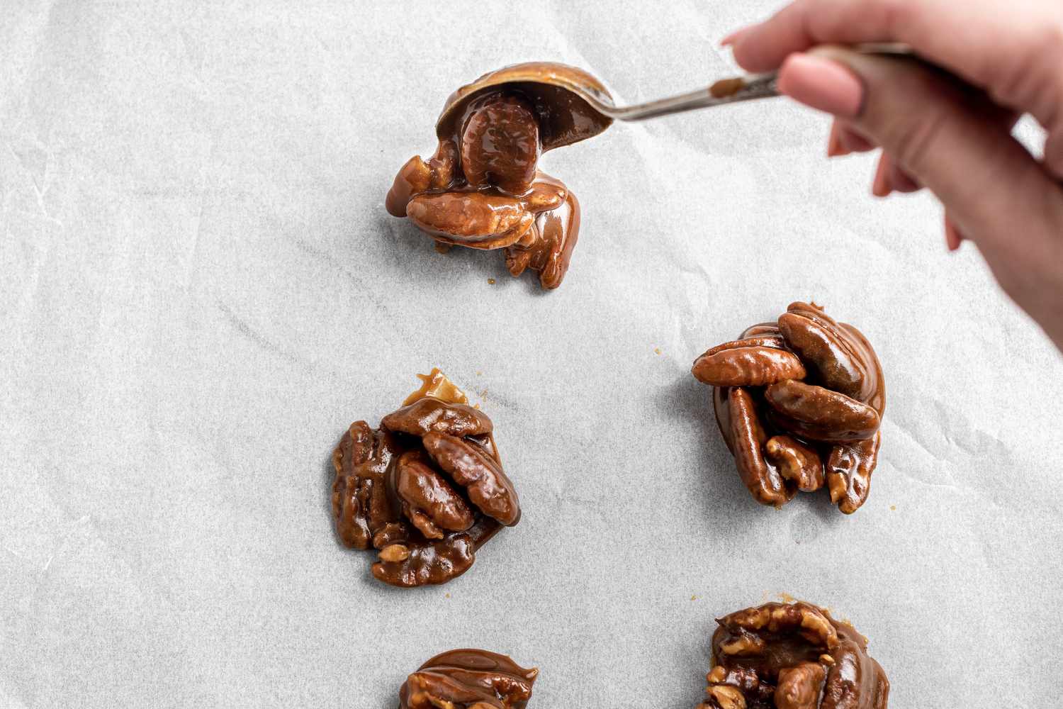 how to Spoon pecan pralines onto parchment paper.