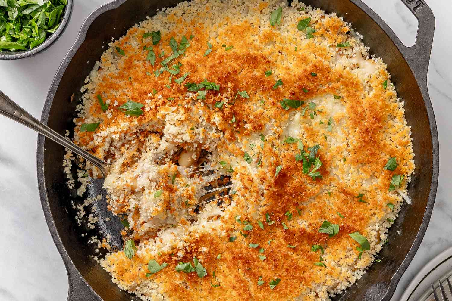 A cast iron skillet with nicely browned baked french onion beans