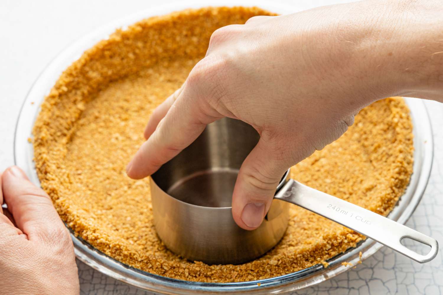 Banoffee Pie Crust Pressed into Pie Pan Using a the Bottom of a Measuring Cup 