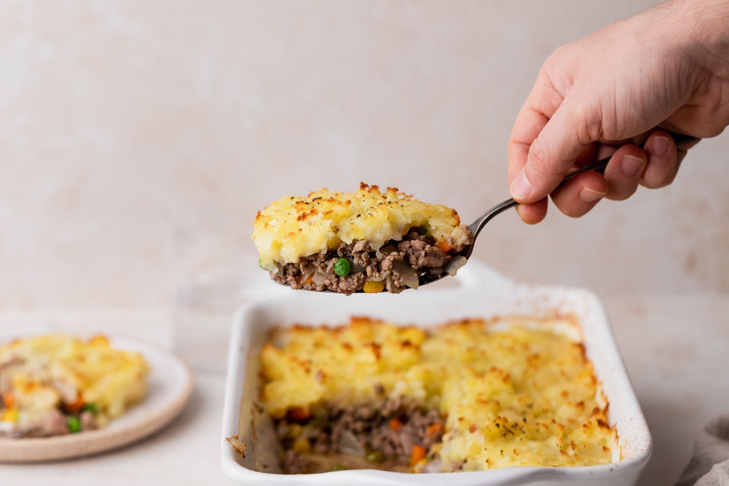 A casserole dish with a piece of shepherd's pie removed.