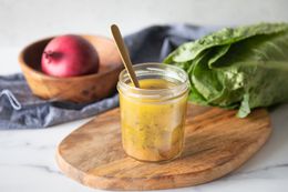 Homemade Italian dressing with spoon in jar.
