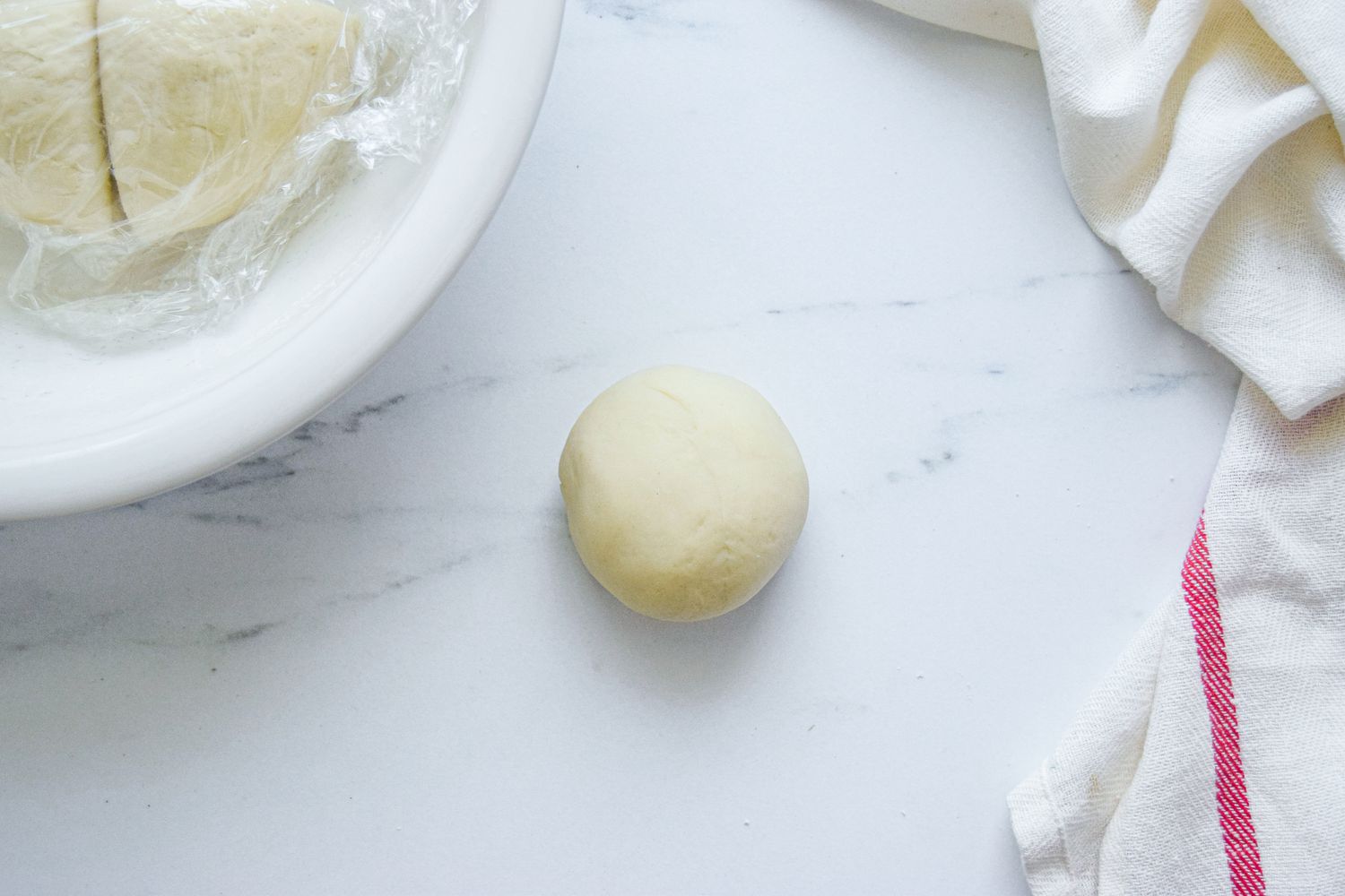 A dough ball on a counter for a scallion pancake recipe.