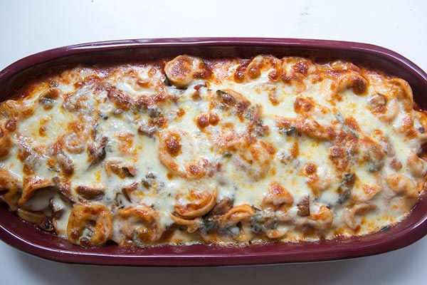 baked tortellini casserole with melted cheese in baking dish