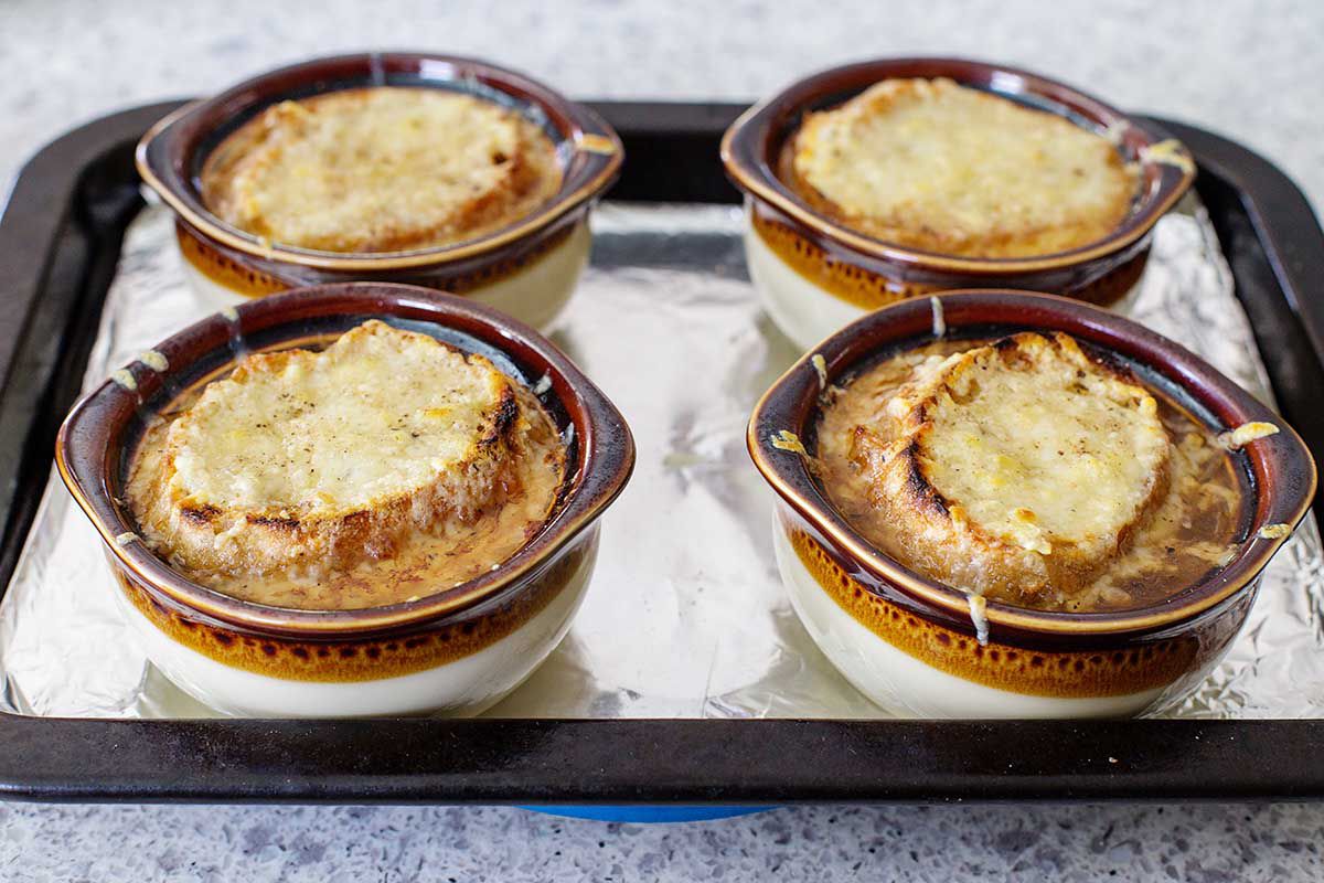 French Onion Soup made in the instant pot in brown stoneware bowls topped with cheese.