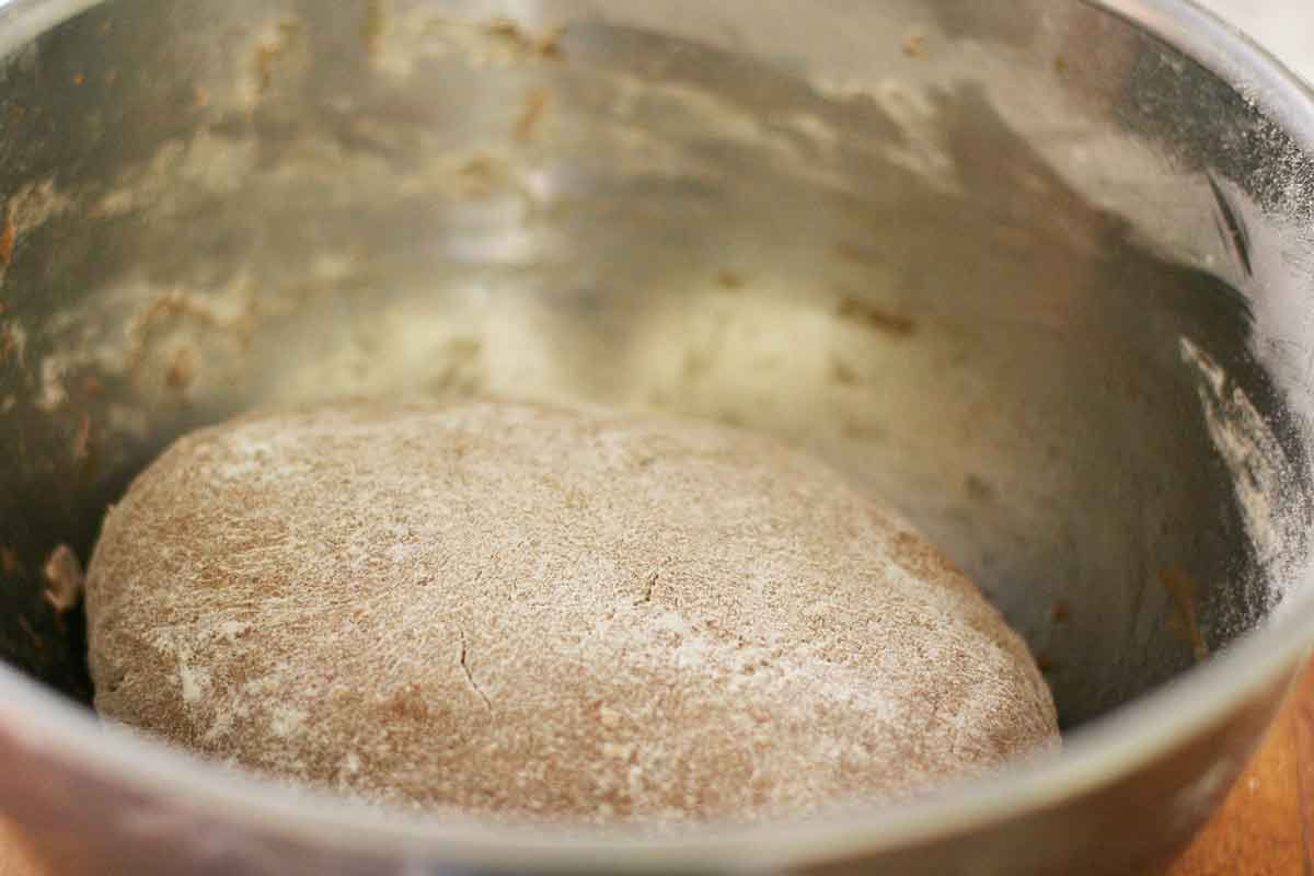 Rye bread dough rising in a metal bowl