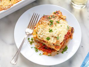 Vegetable moussaka on white plate with fork