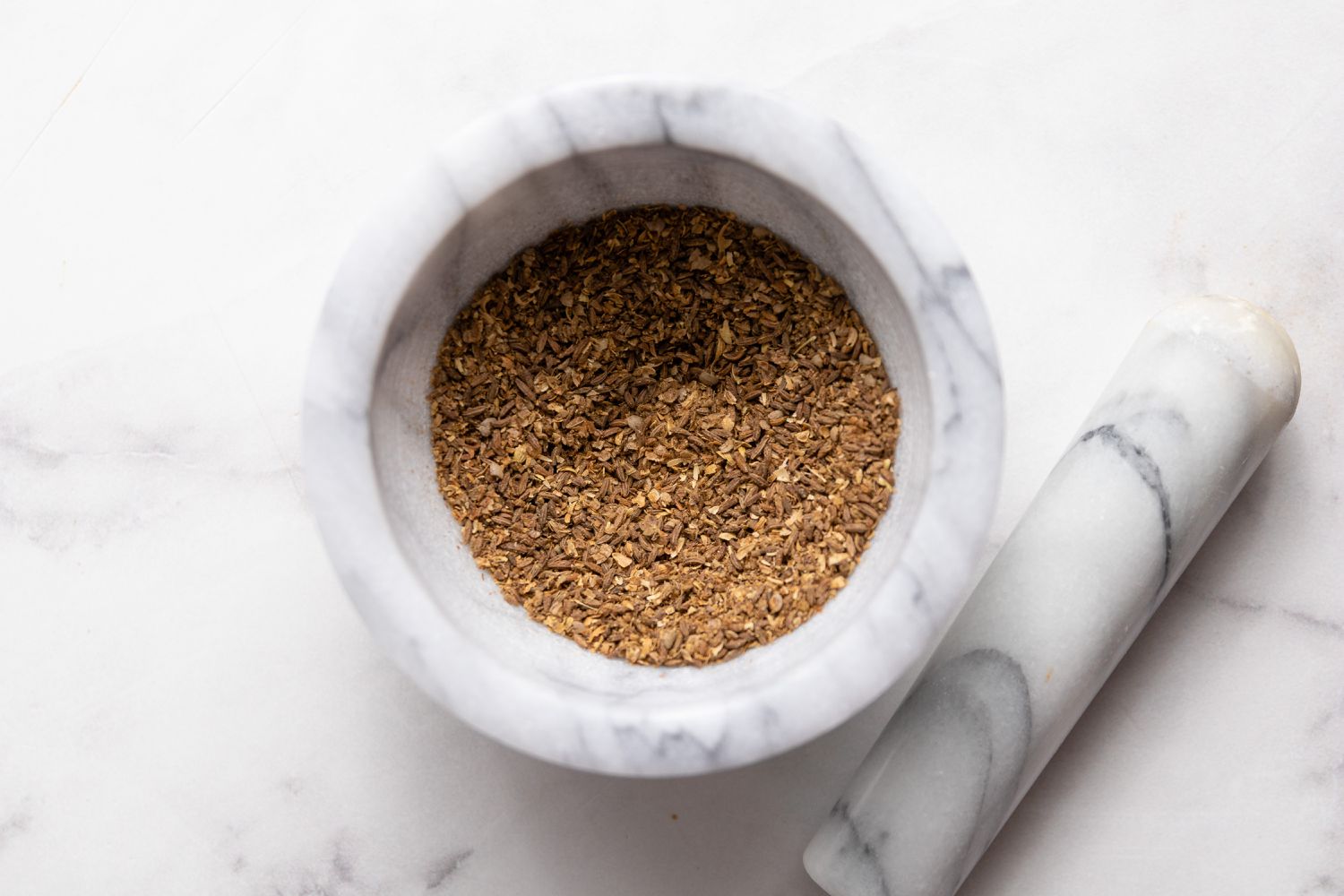 Spices in Mortar and Pestle for Smoked Spatchcock Chicken with Harissa Butter and Grilled Carrots