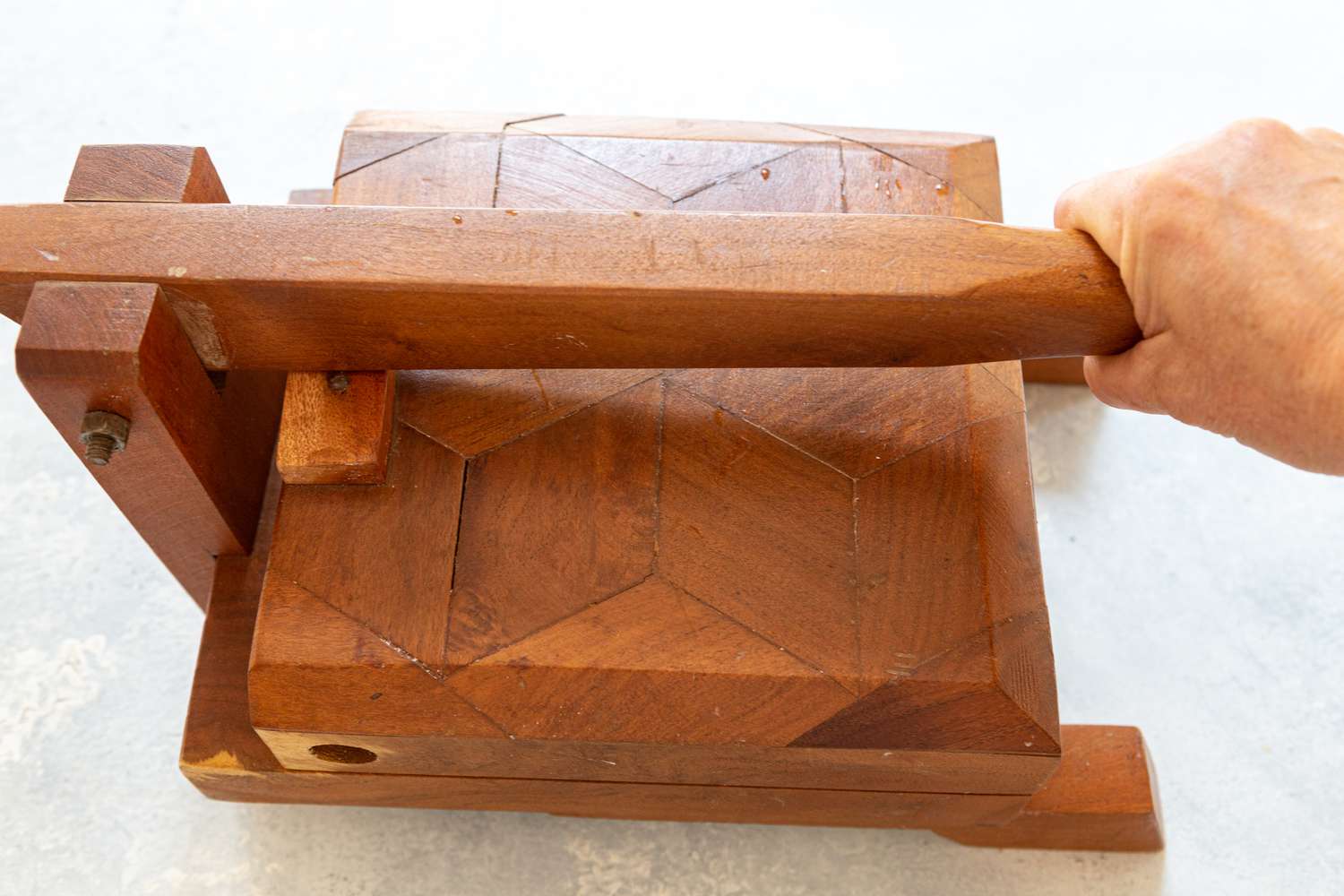 Pressing a tortilla in a wooden tortilla press 