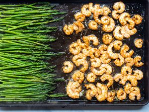 Overhead view of garlic butter sheet pan shrimp and asparagus on a baking sheet.