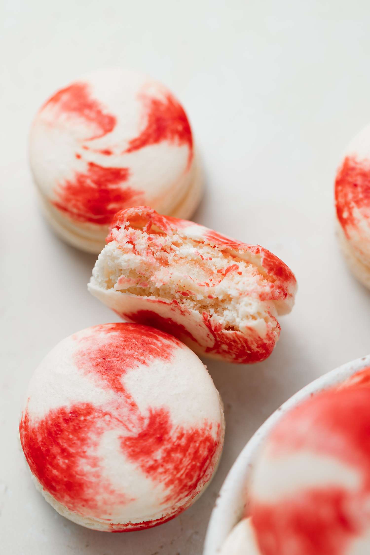 Overhead view of French macarons with peppermint white chocolate fillingwith a bite taken out of one.
