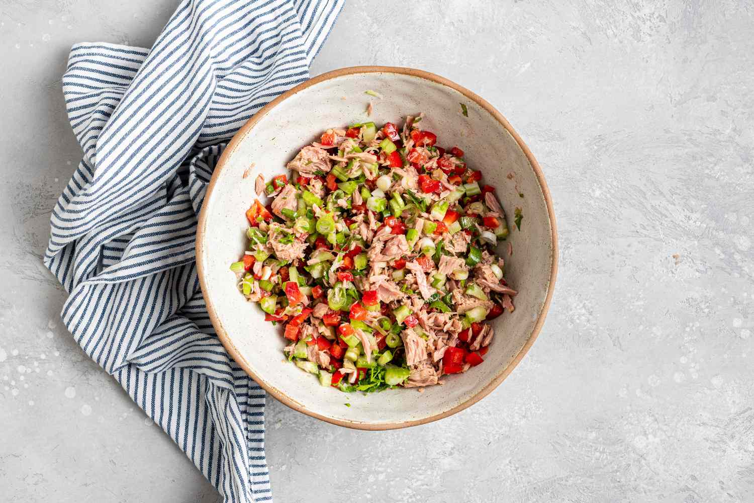 Ingredients mixed in a bowl to make a tuna pasta salad recipe.