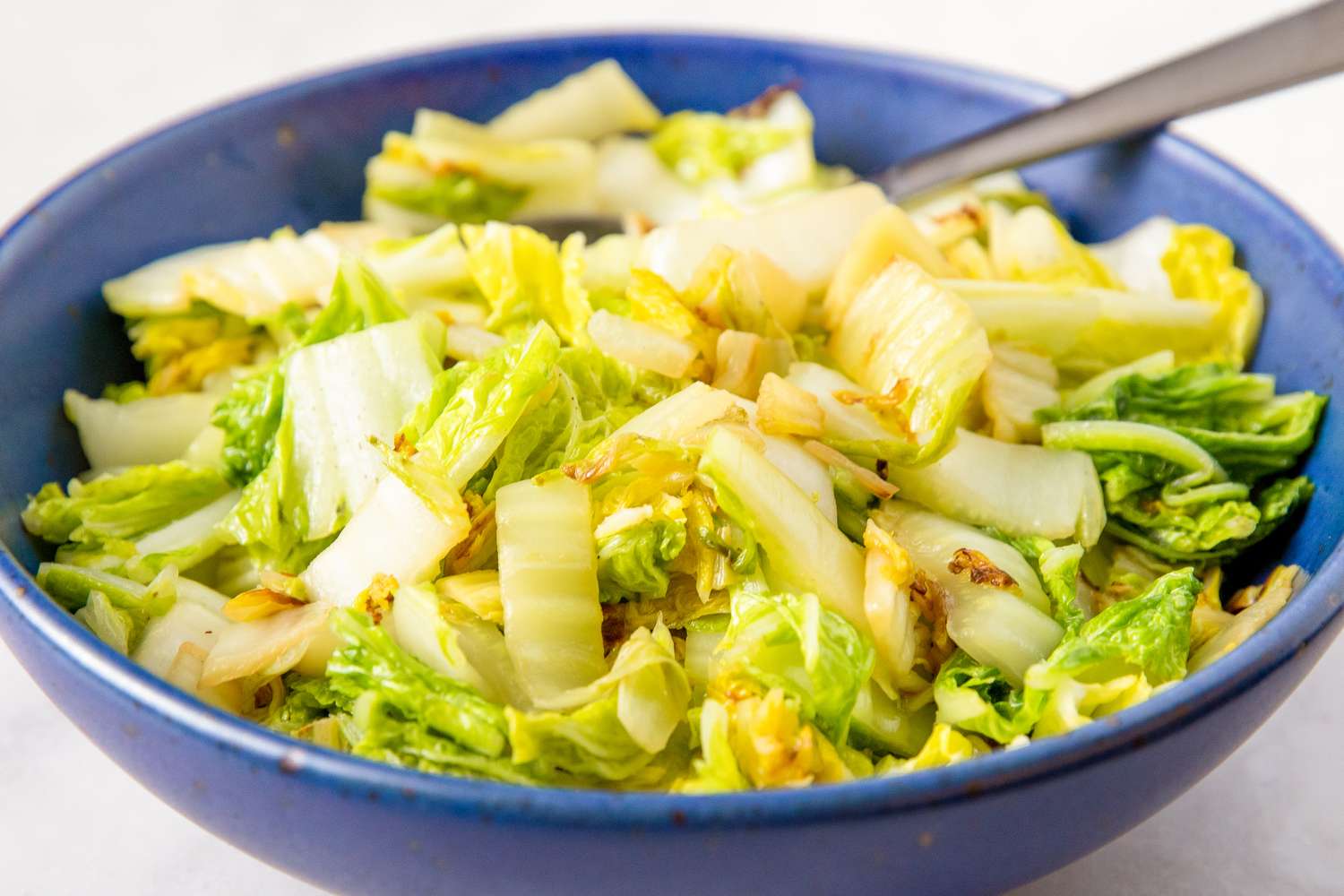 bowl of Stir Fried Napa Cabbage with a spoon