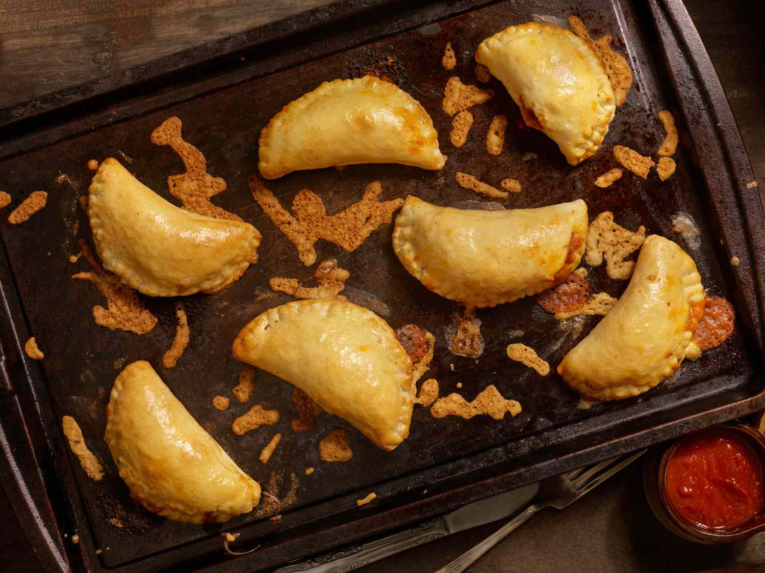 Baked min calzones on a baking sheet