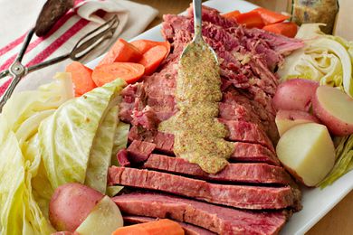 Crockpot Corned Beef - drizzling mustard on sliced corned beef