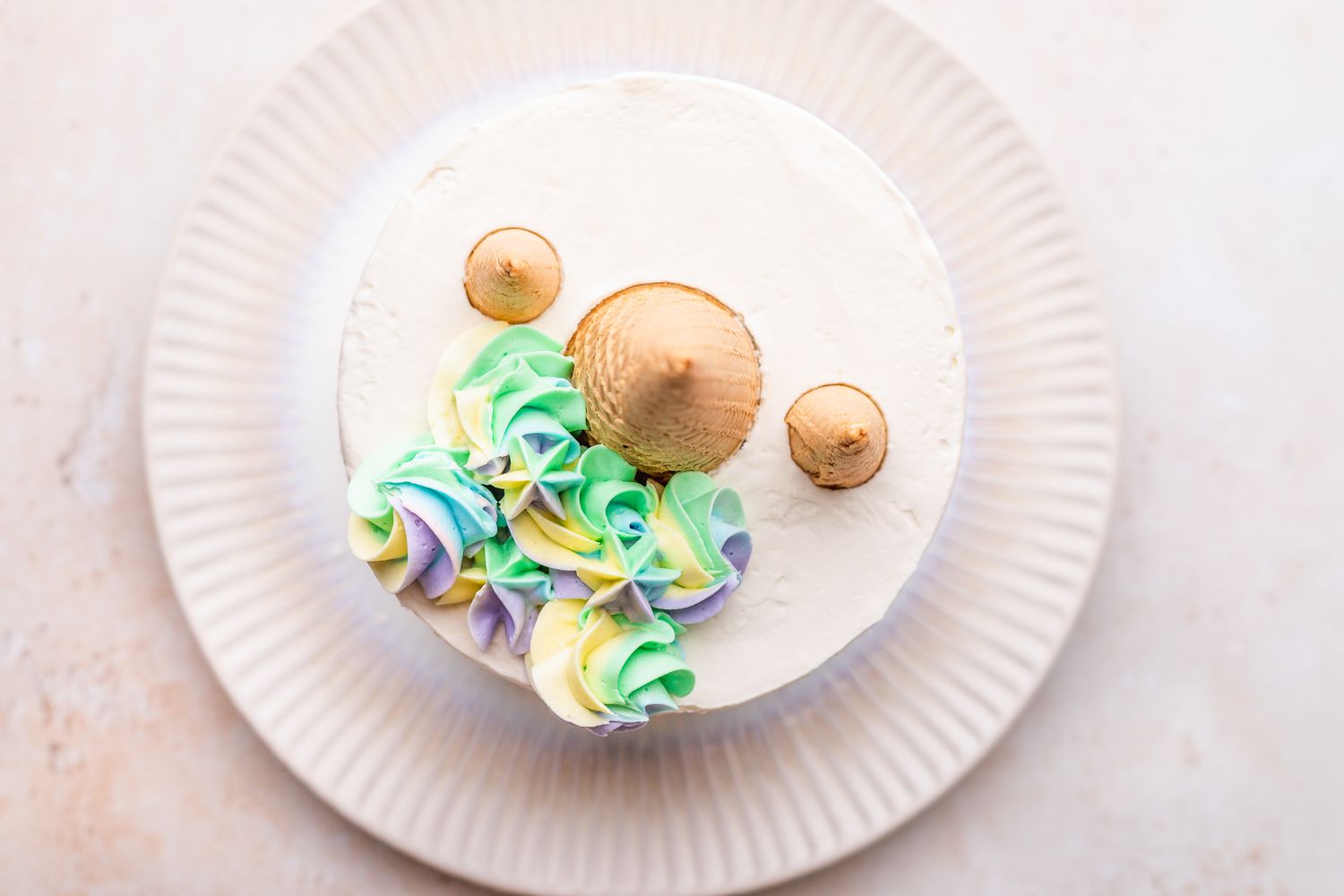 Colorful Buttercream Rosettes and Dollops Next to Cones on Unicorn Cake 