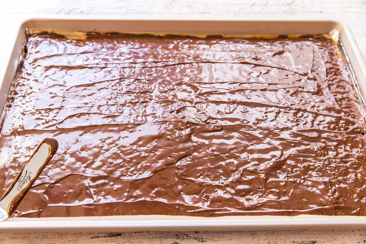 How to Make Matzo Toffee - melted chocolate spread over matzo and toffee in a sheet pan