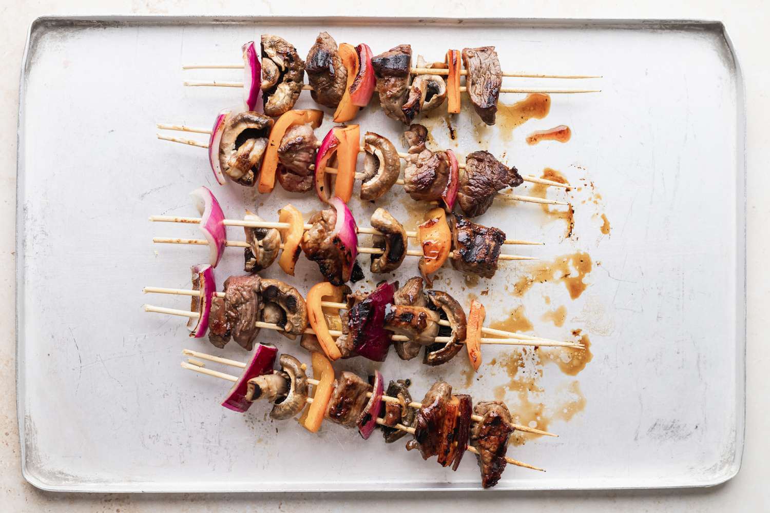 A baking sheet of grilled beef kabobs.