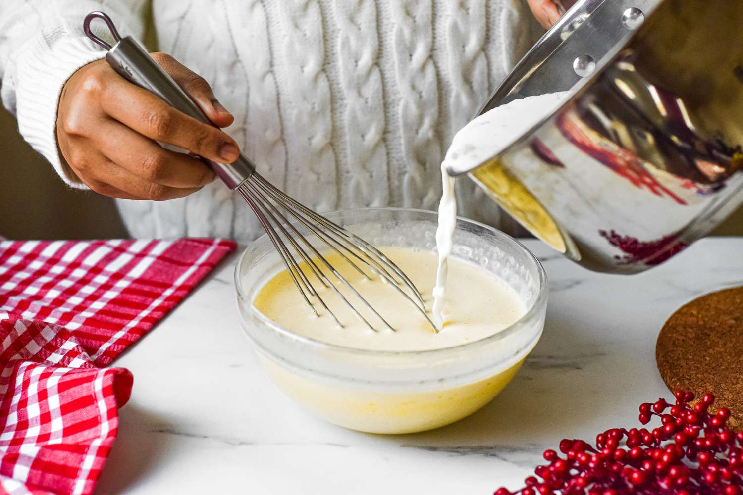 Pouring creamy eggnog into a bowl as it's being whisked