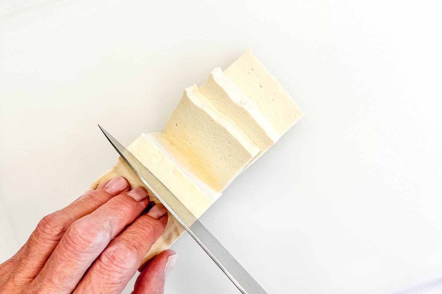 Tofu sliced into 1/4 inch thick planks for homemade budae jjigae (army base stew) recipe