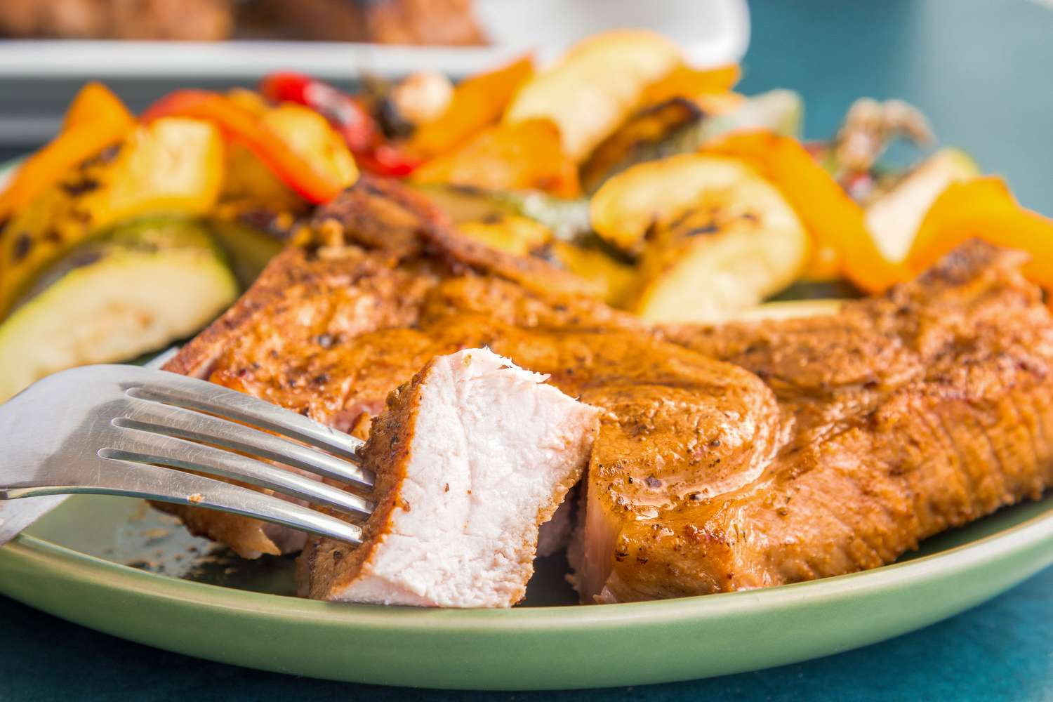 Grilled Pork Chops on Plate with a Piece on Fork