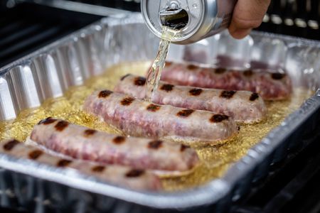 Beer Poured into Tray of Bratwurst