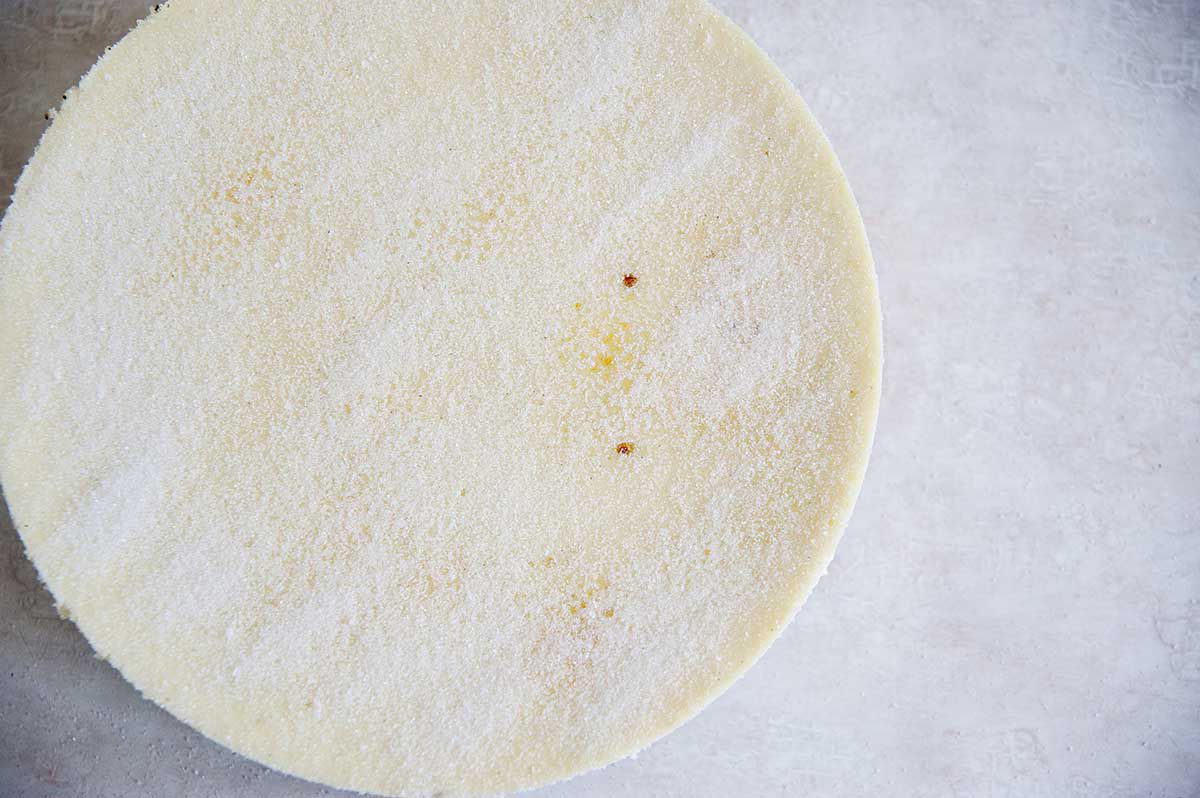 Creme Brulee cheesecake with granulated sugar dusted over the top. waiting to be bruleed.