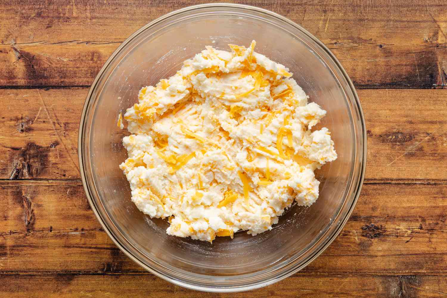 potato middle, sour cream, and cheddar mixed together in a bowl for cheeseburger stuffed baked potatoes recipe