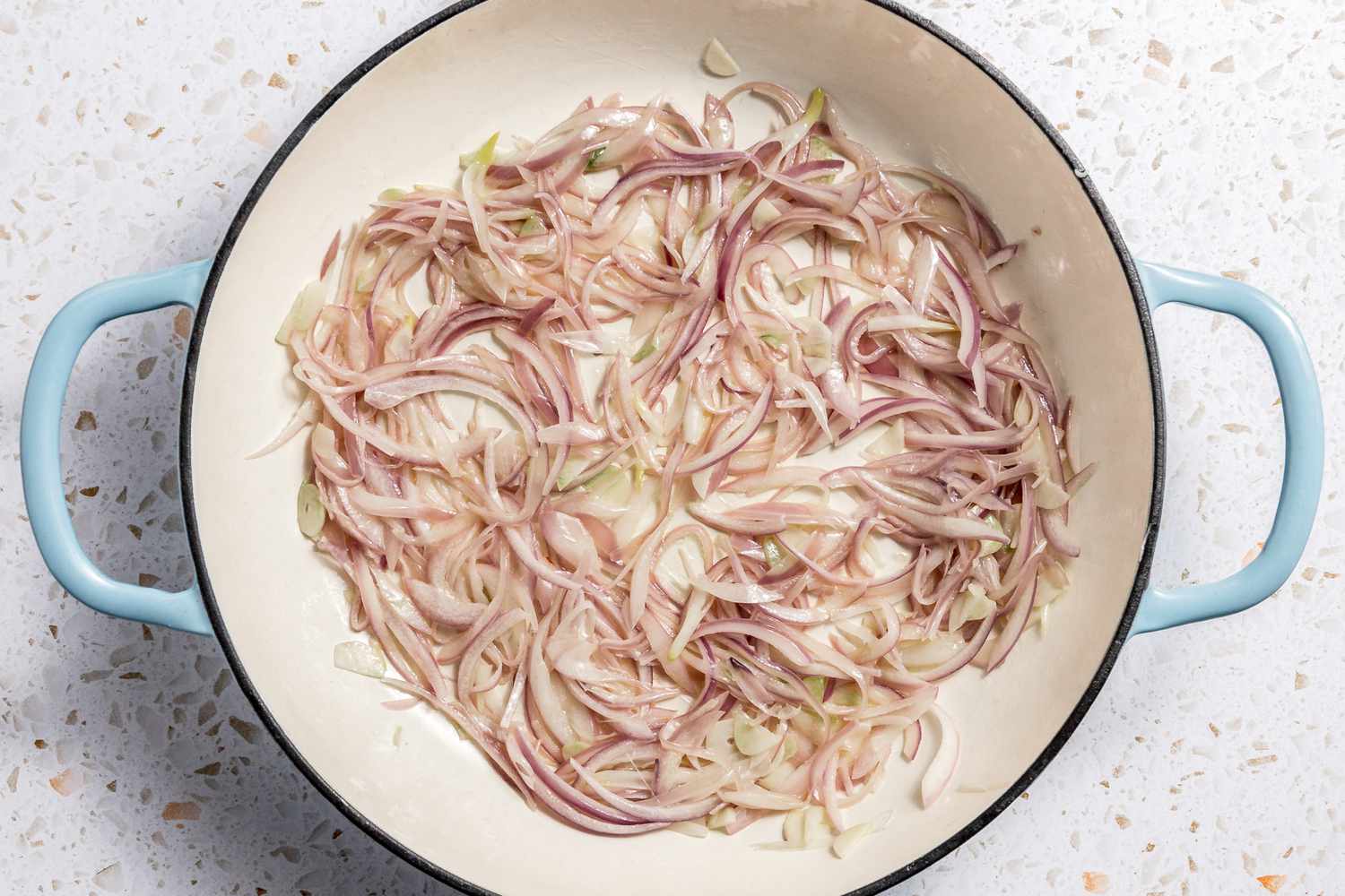 Sliced Red Onions and Garlic Cooking in a Pot for Paccheri With Sausage Ragu