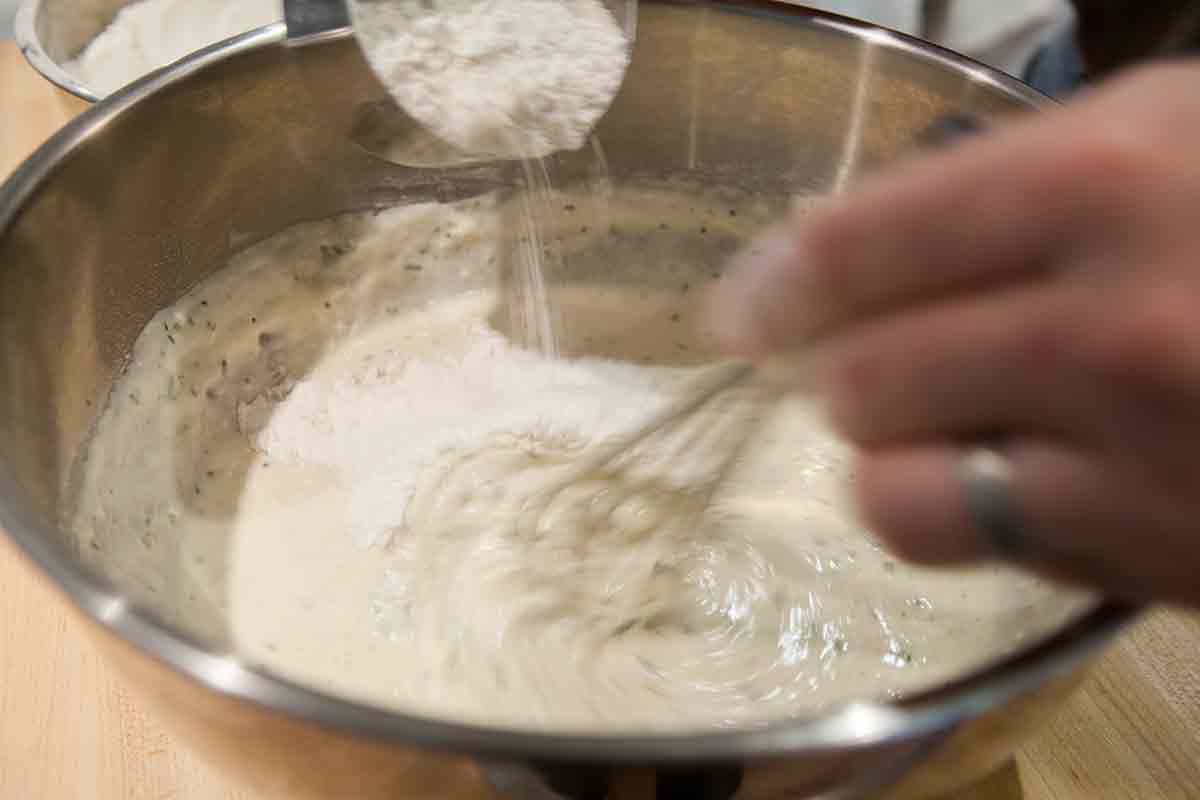Add the flour for rosemary focaccia a little at a time
