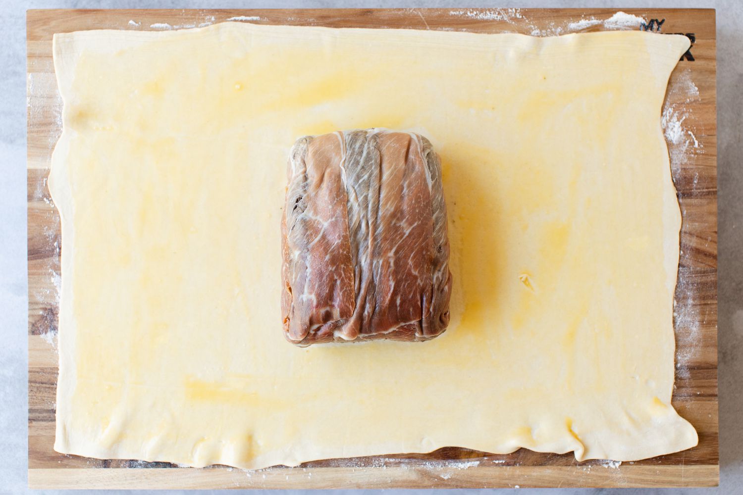 Beef Wellington Meat Parcel Placed on a Sheet of Puff Pastry